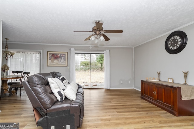 living room with crown molding, ceiling fan, light hardwood / wood-style flooring, and a textured ceiling