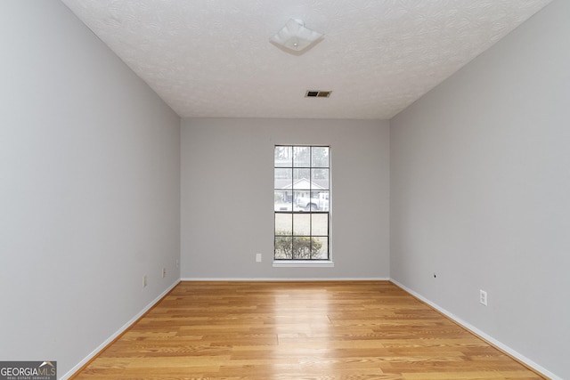 empty room featuring light hardwood / wood-style flooring and a textured ceiling