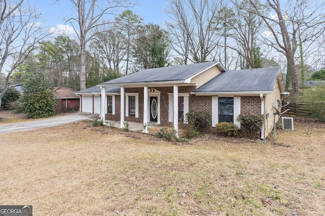 ranch-style house featuring a porch, a garage, and a front yard