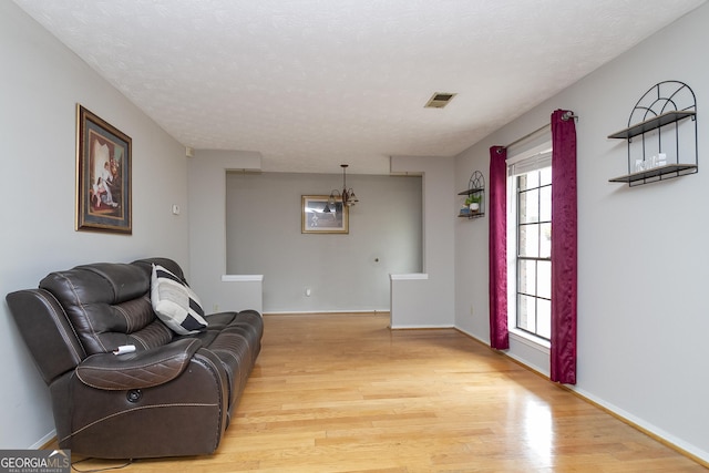 living room featuring light hardwood / wood-style flooring and a textured ceiling