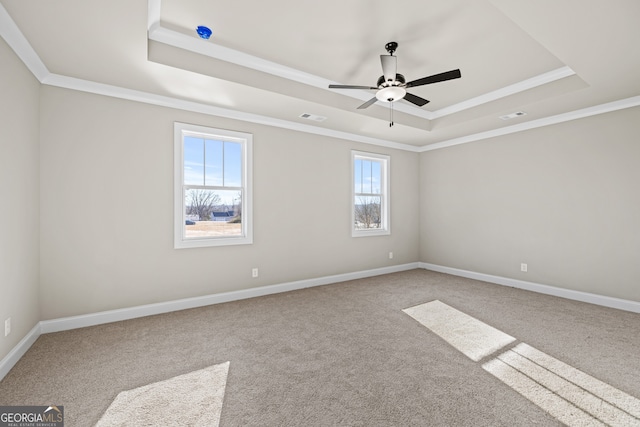 carpeted spare room featuring ornamental molding, ceiling fan, and a tray ceiling