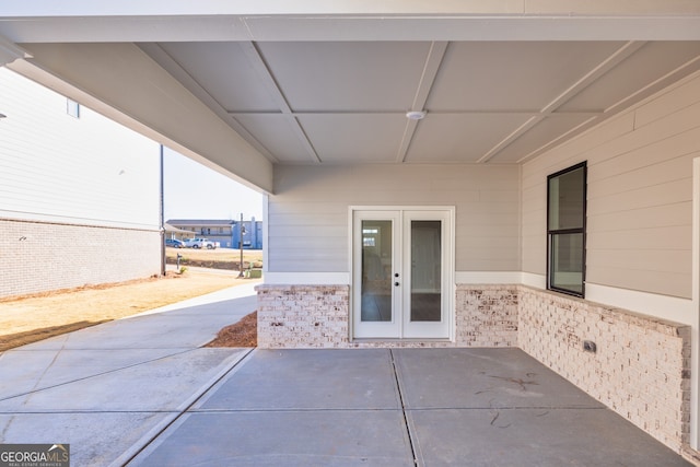 view of exterior entry with a patio and french doors