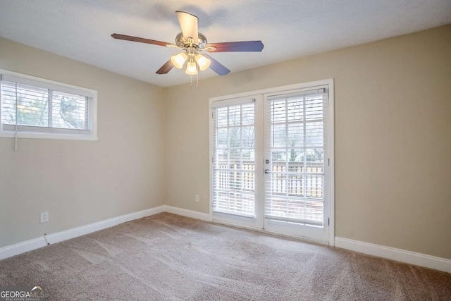 unfurnished room featuring carpet flooring, a wealth of natural light, and ceiling fan