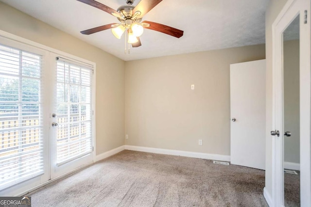 empty room featuring carpet, ceiling fan, and french doors