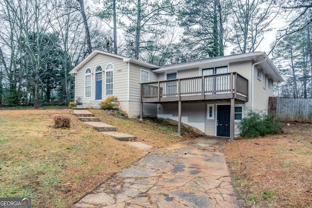 view of front property with a deck and a front lawn