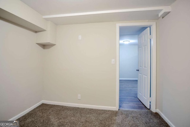 unfurnished room featuring dark carpet