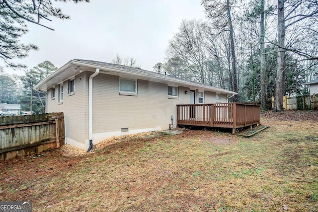 back of property with a wooden deck and a yard