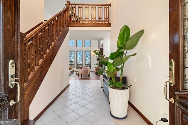 entryway featuring a towering ceiling and light tile patterned flooring