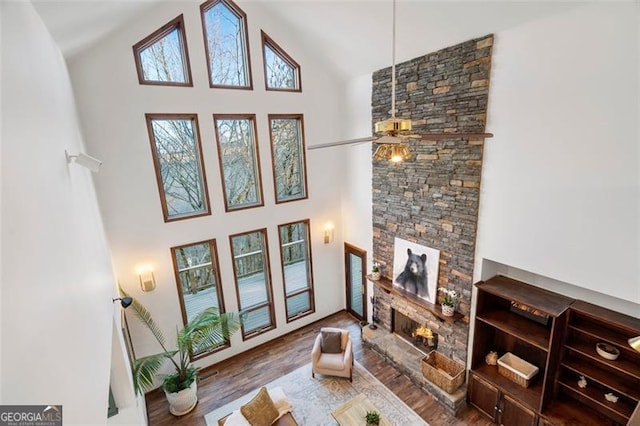 living room with dark wood-type flooring, a fireplace, and high vaulted ceiling