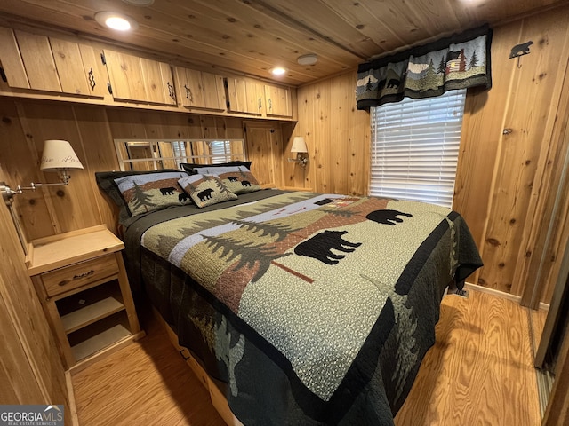 bedroom featuring light wood-type flooring, wood ceiling, and wood walls