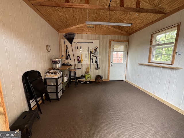 miscellaneous room with lofted ceiling and wood walls