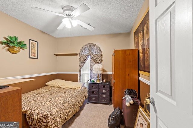 carpeted bedroom featuring ceiling fan and a textured ceiling