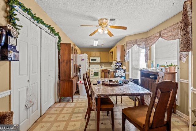 dining space featuring ceiling fan and a textured ceiling