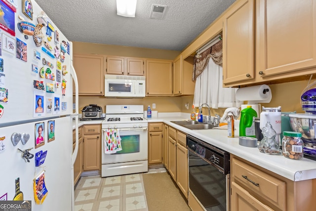 kitchen featuring white appliances, light brown cabinetry, sink, and a textured ceiling