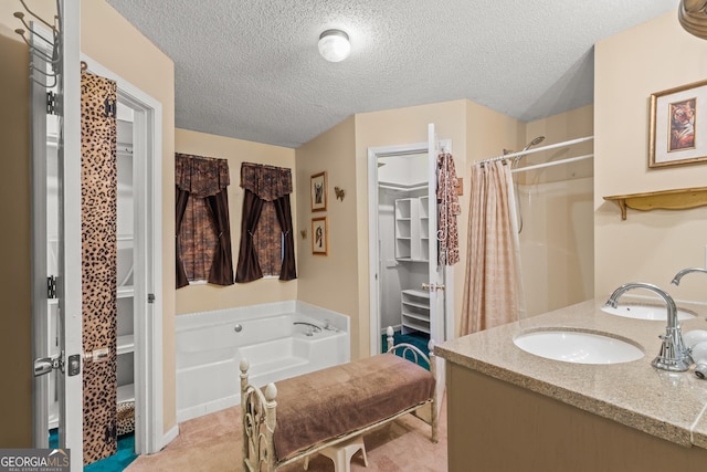 bathroom with vanity, plus walk in shower, and a textured ceiling