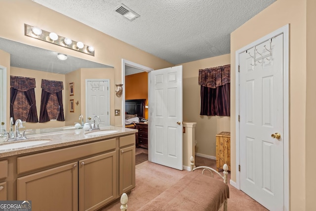 bathroom with vanity, a textured ceiling, and toilet