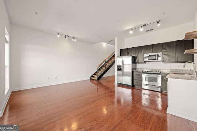 kitchen featuring stainless steel appliances, rail lighting, sink, and dark wood-type flooring