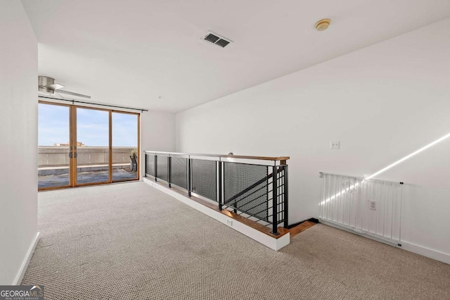 hall featuring carpet floors and a wall of windows