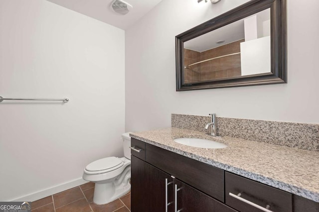 bathroom with tile patterned flooring, vanity, and toilet