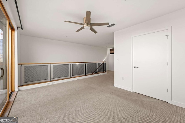 empty room featuring ceiling fan and light colored carpet