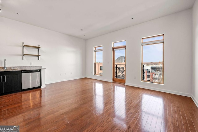 unfurnished living room with dark hardwood / wood-style floors and indoor wet bar