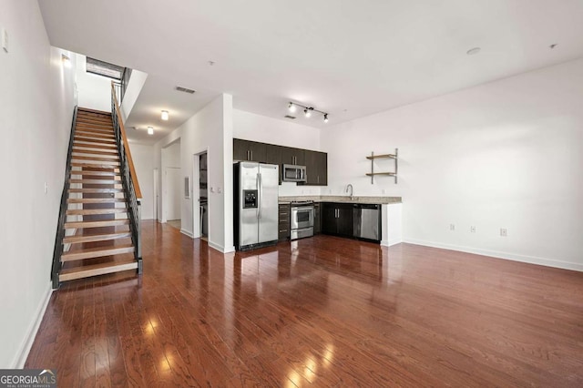 kitchen featuring dark brown cabinetry, sink, dark wood-type flooring, and stainless steel appliances