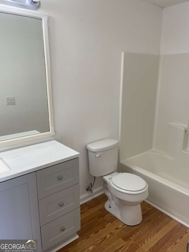 full bathroom with vanity, wood-type flooring, bathtub / shower combination, and toilet