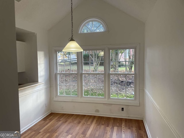 unfurnished dining area with lofted ceiling and hardwood / wood-style floors