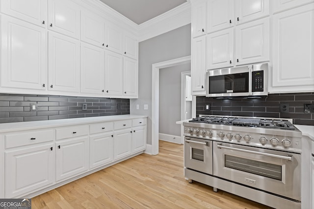 kitchen with white cabinets, decorative backsplash, ornamental molding, light hardwood / wood-style floors, and stainless steel appliances