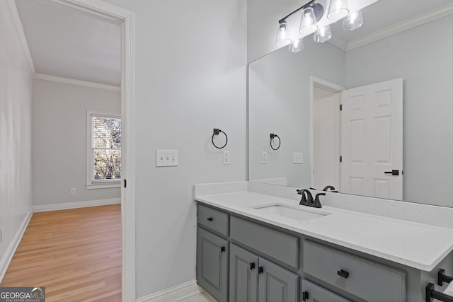 bathroom with ornamental molding, hardwood / wood-style floors, and vanity