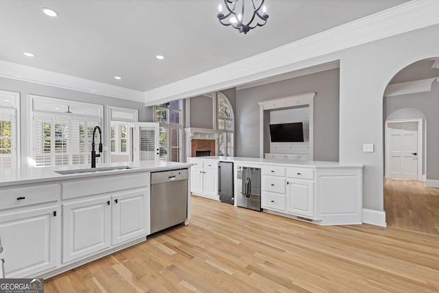 kitchen featuring dishwasher, sink, white cabinets, and ornamental molding