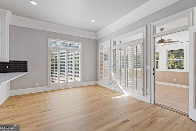 unfurnished dining area featuring ornamental molding and light hardwood / wood-style floors