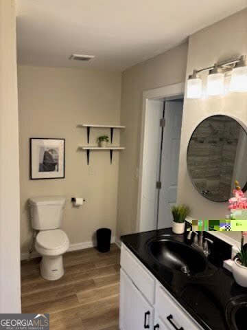 bathroom with vanity, hardwood / wood-style flooring, and toilet