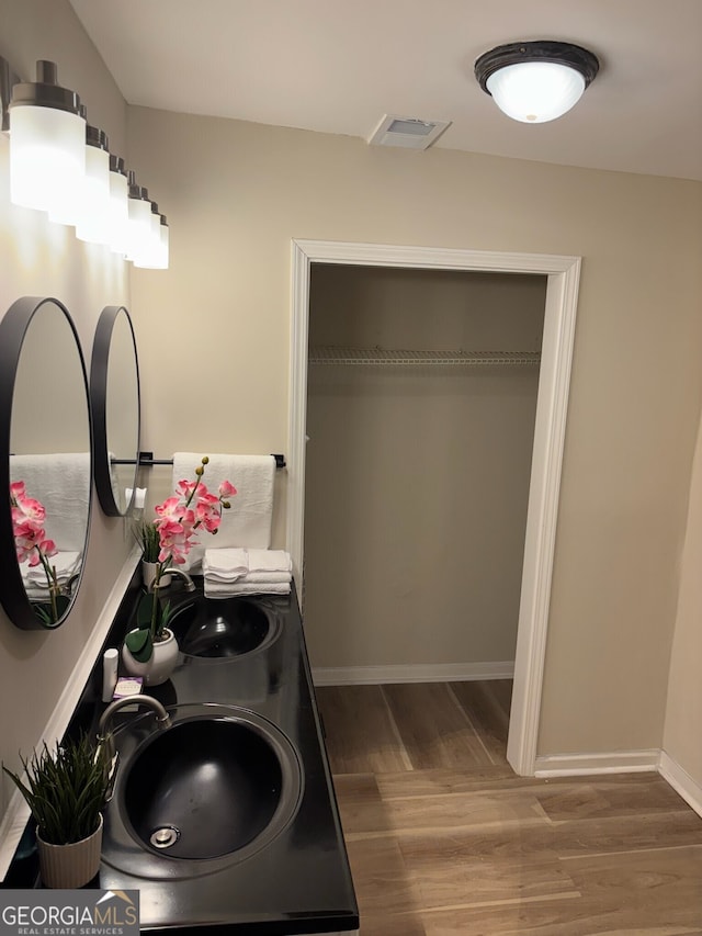 clothes washing area with hardwood / wood-style flooring and sink