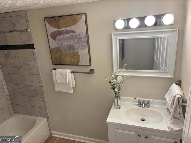 bathroom featuring vanity and tiled shower / bath