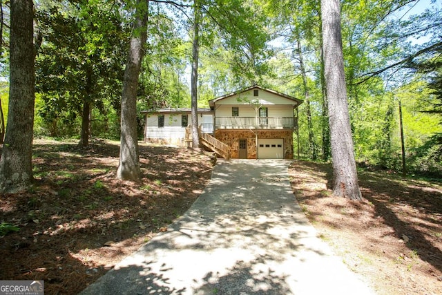 view of front of property with concrete driveway, stairway, a porch, and an attached garage