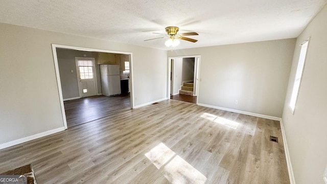 spare room featuring ceiling fan, a textured ceiling, and light wood-type flooring