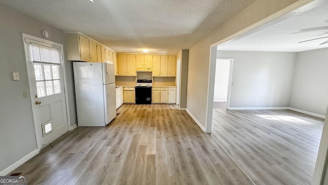 kitchen with freestanding refrigerator, light wood-style floors, range with electric cooktop, and a textured ceiling
