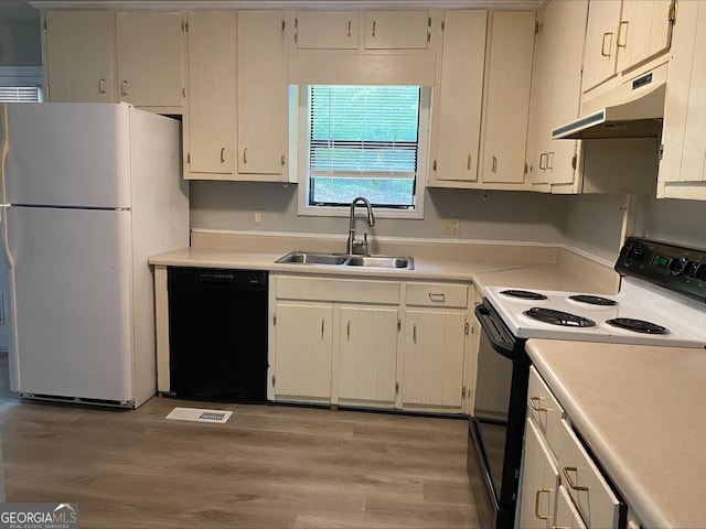 kitchen with a sink, freestanding refrigerator, black dishwasher, electric stove, and under cabinet range hood
