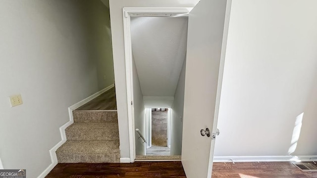 stairs with visible vents and wood finished floors