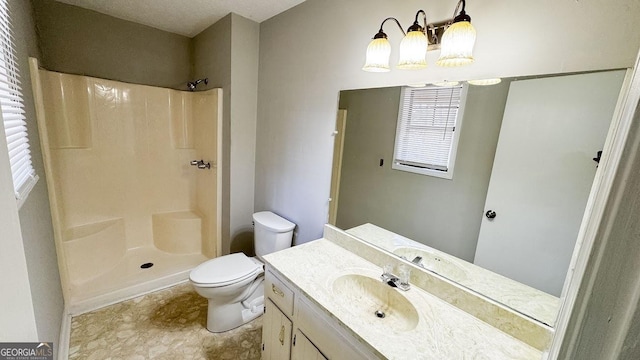 bathroom featuring a notable chandelier, toilet, vanity, and walk in shower