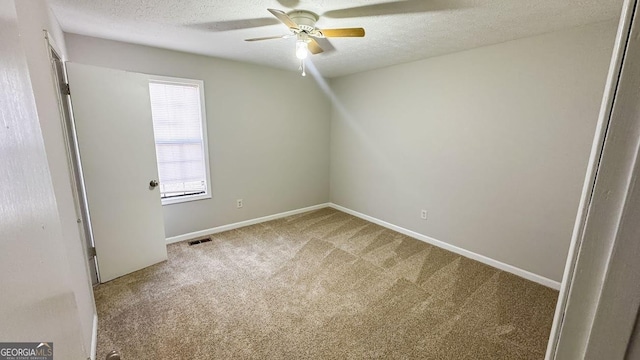 carpeted empty room featuring ceiling fan and a textured ceiling