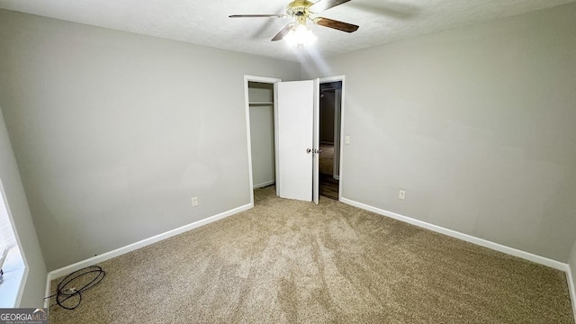 unfurnished bedroom featuring ceiling fan, light colored carpet, and a textured ceiling