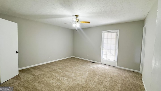unfurnished room with ceiling fan, carpet flooring, baseboards, and visible vents
