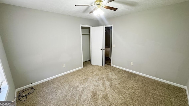 unfurnished bedroom with a closet, a textured ceiling, carpet floors, a ceiling fan, and baseboards