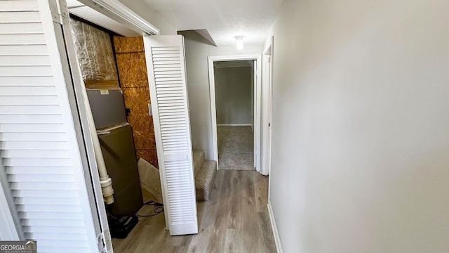 corridor with baseboards and wood finished floors
