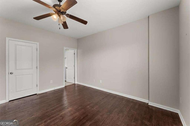 spare room featuring dark wood-type flooring and ceiling fan