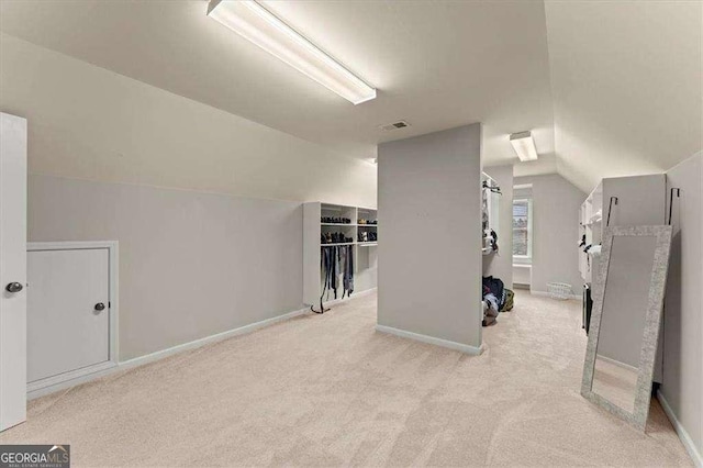 bonus room with light carpet and vaulted ceiling