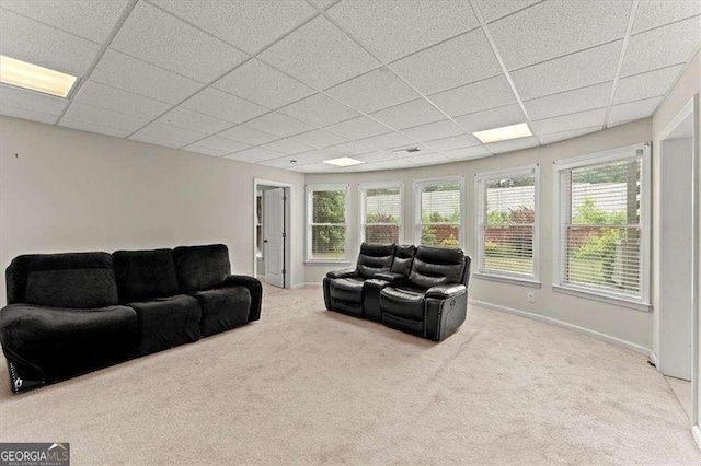 living room featuring light carpet and a drop ceiling