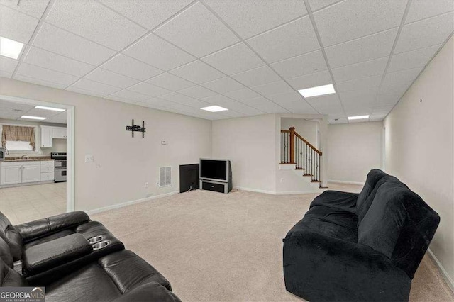 living room with light carpet, sink, and a paneled ceiling